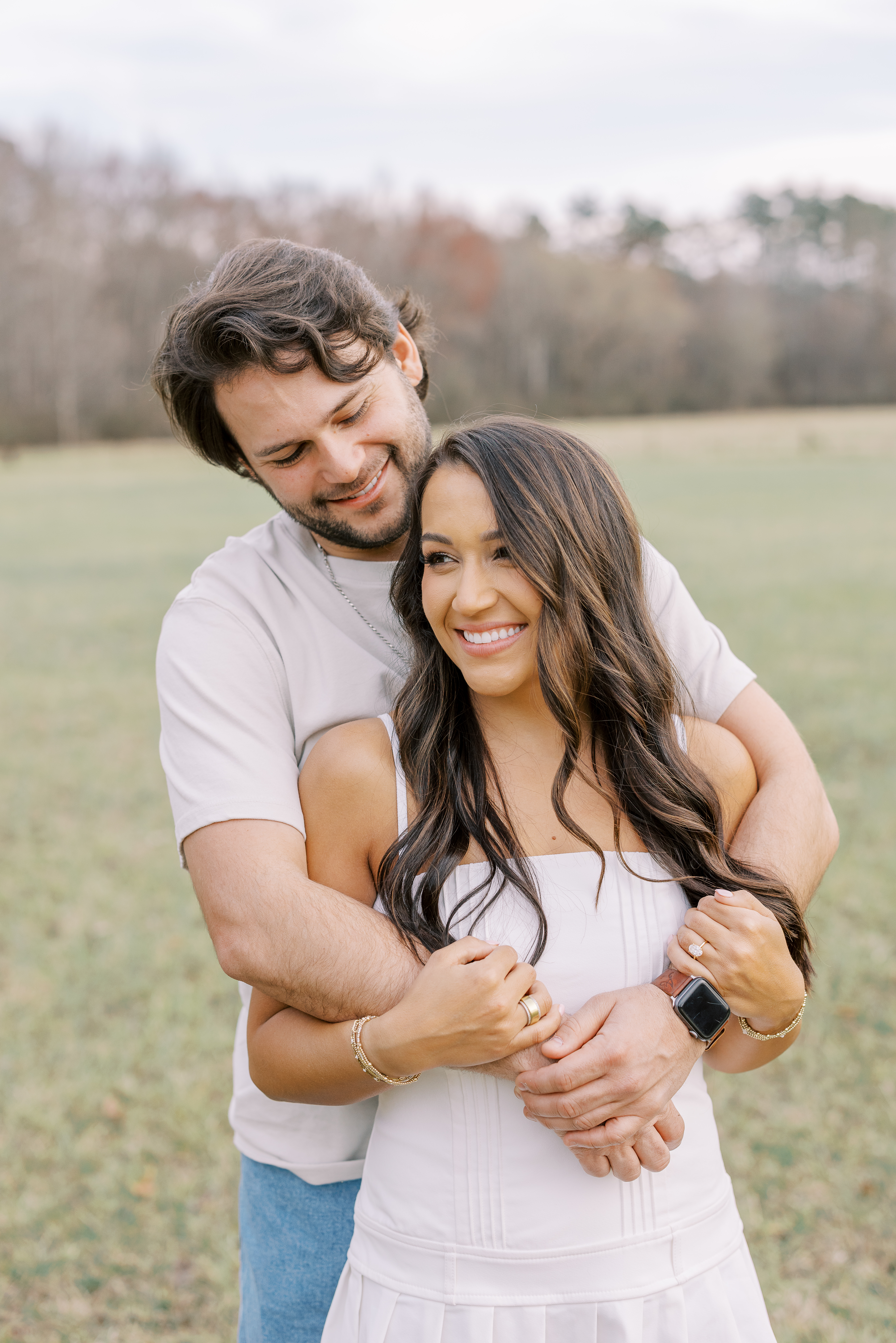a couple having an engagement photoshoot in a field in georgia