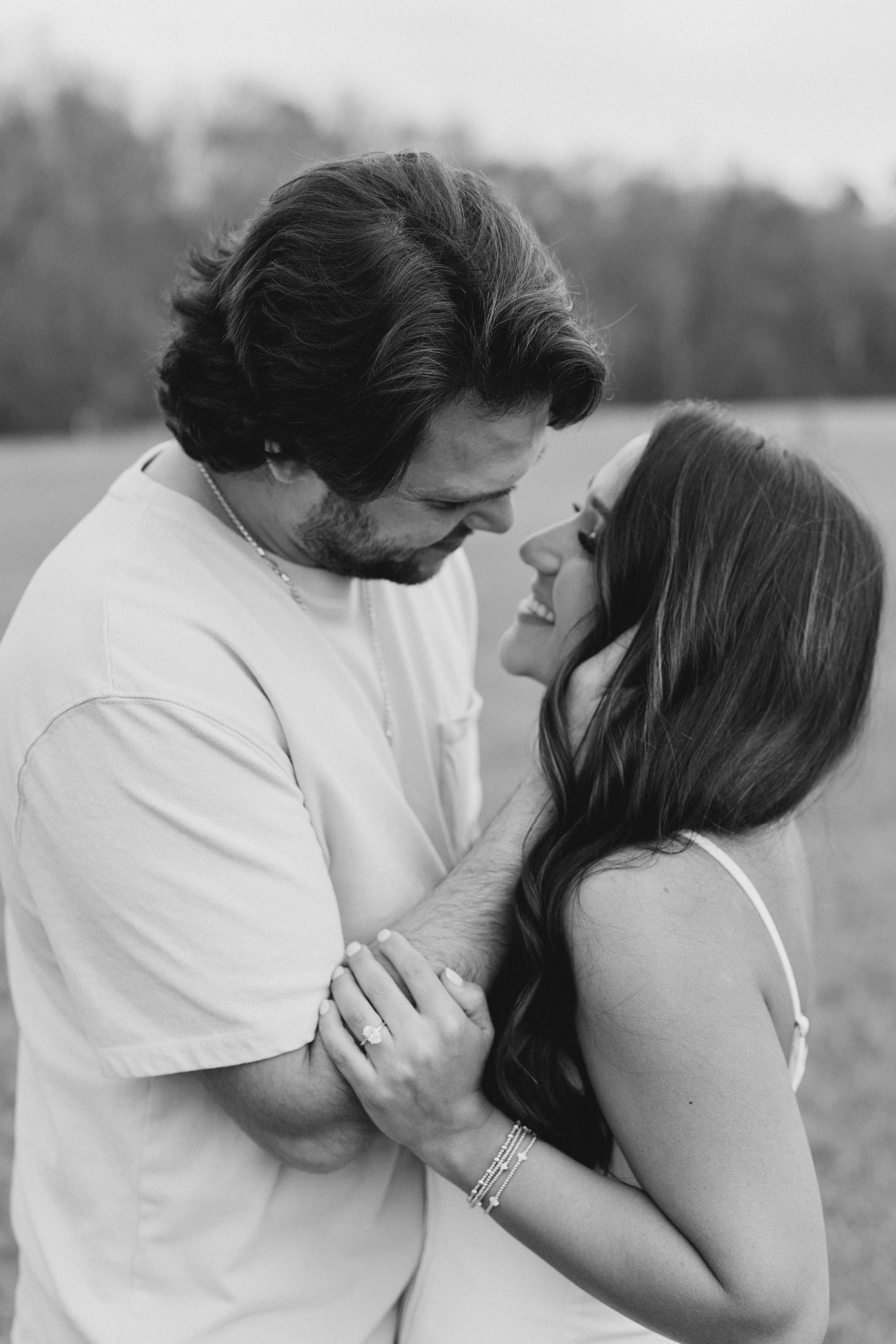 a couple having an engagement photoshoot in a field in georgia