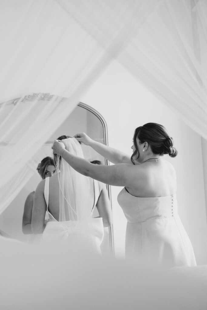 bridesmaid putting on bride's veil