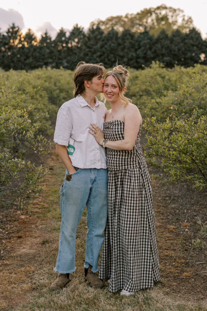 couple kissing in a blueberry field